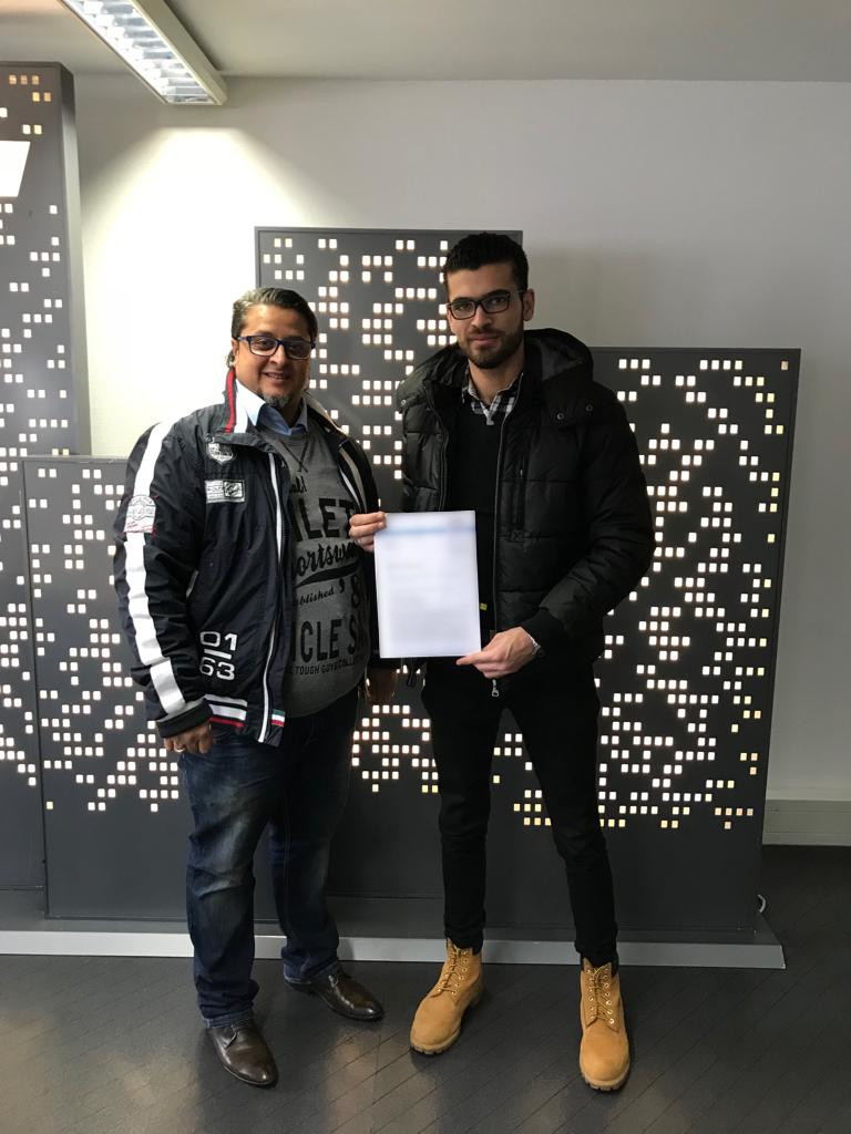 Herr Amdeov mit einem unserer Mitarbeiter bei der unterzeichnung der Übernahme des Mitarbeiters.