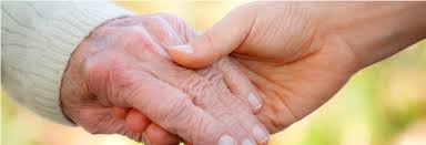 Eine alte und eine junge Hand halten in einander.